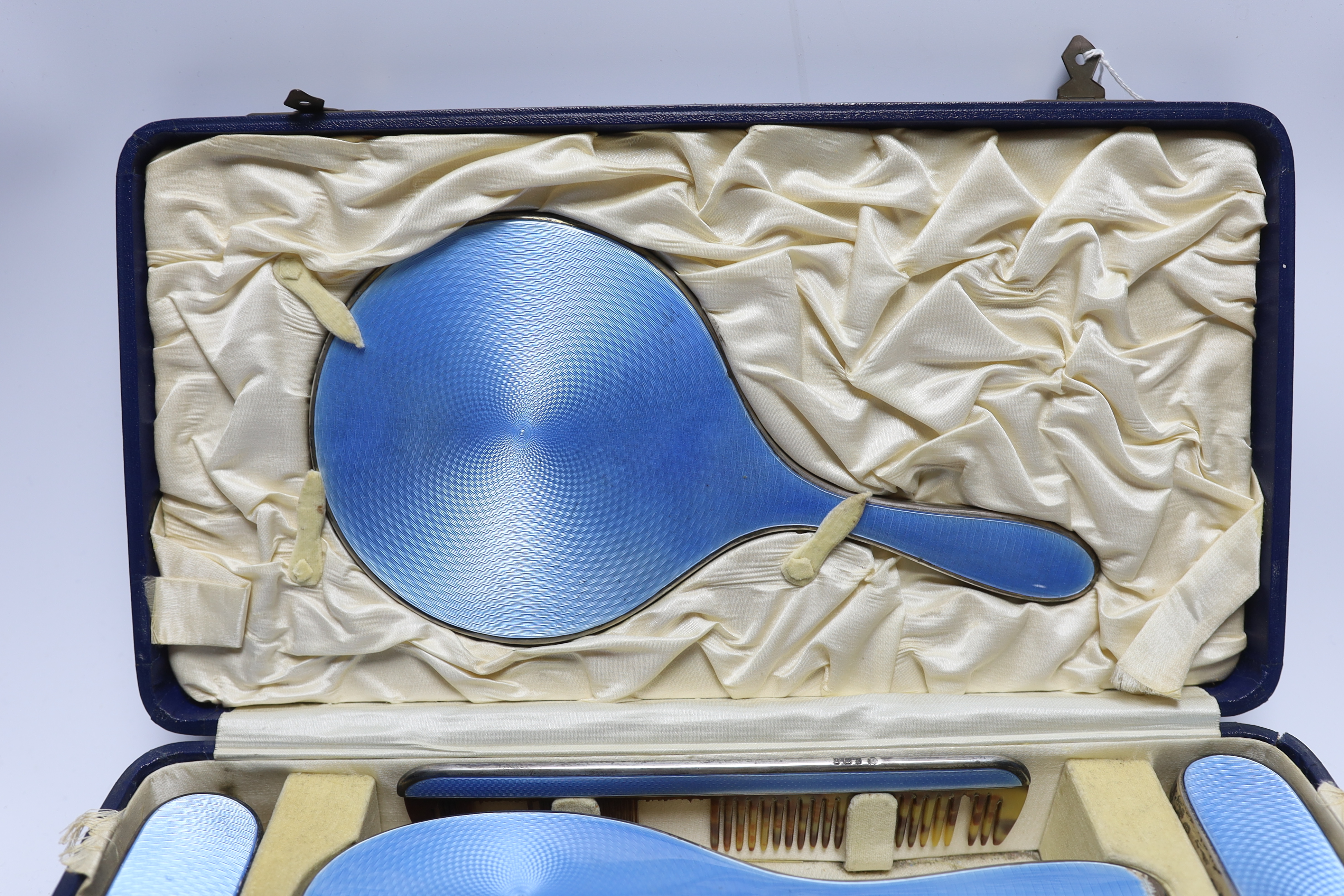 A cased George V silver and blue guilloche enamel mounted six piece mirror and brush set, Charles Henry Dumenil, London, 1932.